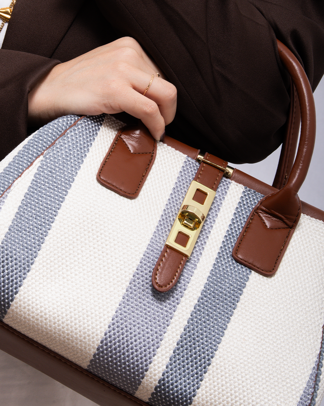 Bolso tipo bucket en lona rayada con herrajes metálicos